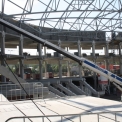 Pod ocelovou střešní konstrukcí se dokončuje ukládání tribunových nosníků.