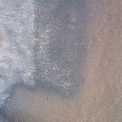 Hnědá patina a vrstva fixovaných povrchových nečistot překrývala a uzavírala povrch kamene (na fotografii je detail zkoušky čištění s mezifází – tmavě šedá, po odstranění novodobé patiny – hnědá).