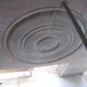 Na pohledových stropech v nadzemních podlažích se objevují kruhy z lan a hadic vložených do bednění.