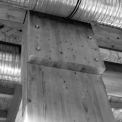 Pohľady do hotovej budovy zvnútra: bezpečné spojenie drevených nosníkov pod strechou